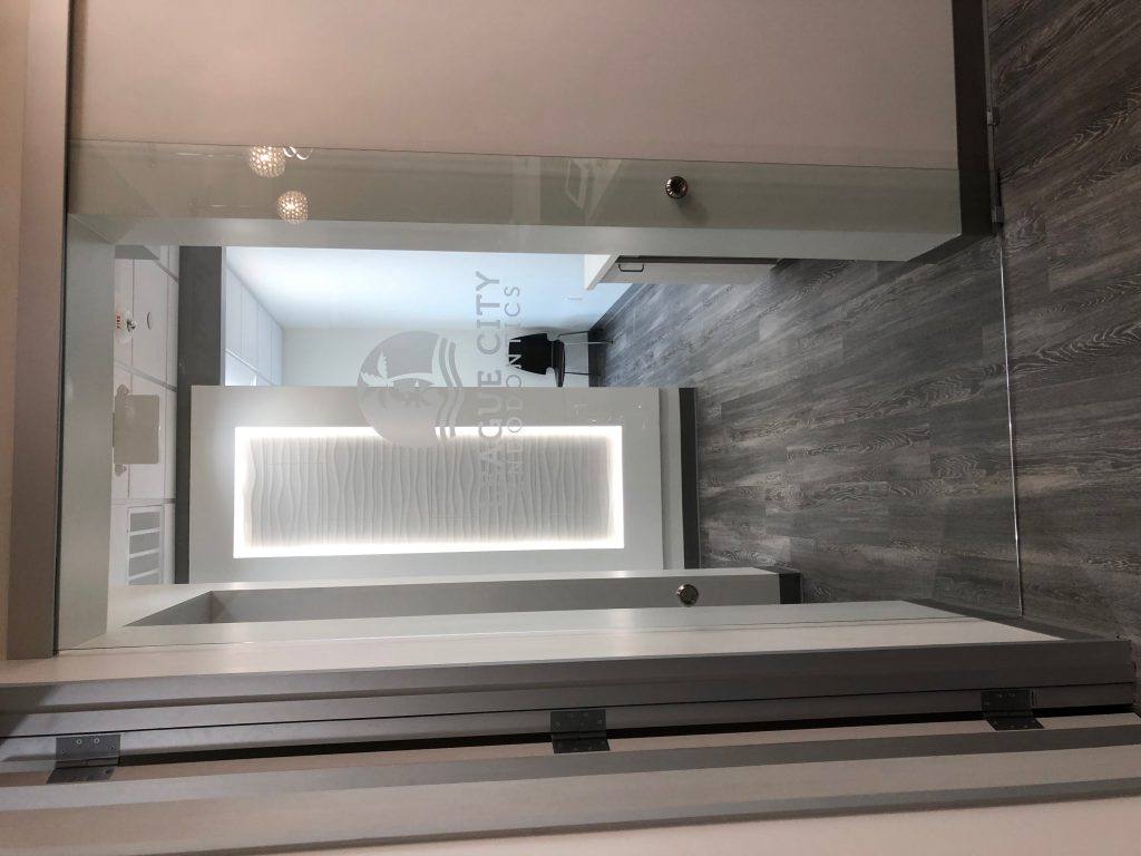 Modern interior hallway with sleek white doors and gray flooring.