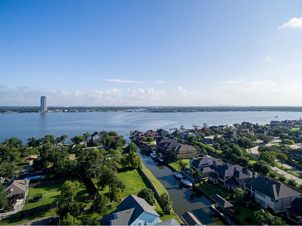 A suburban neighborhood near a large body of water under a clear blue sky.